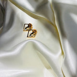 Solid yellow gold diamond shaped earrings with black centre
