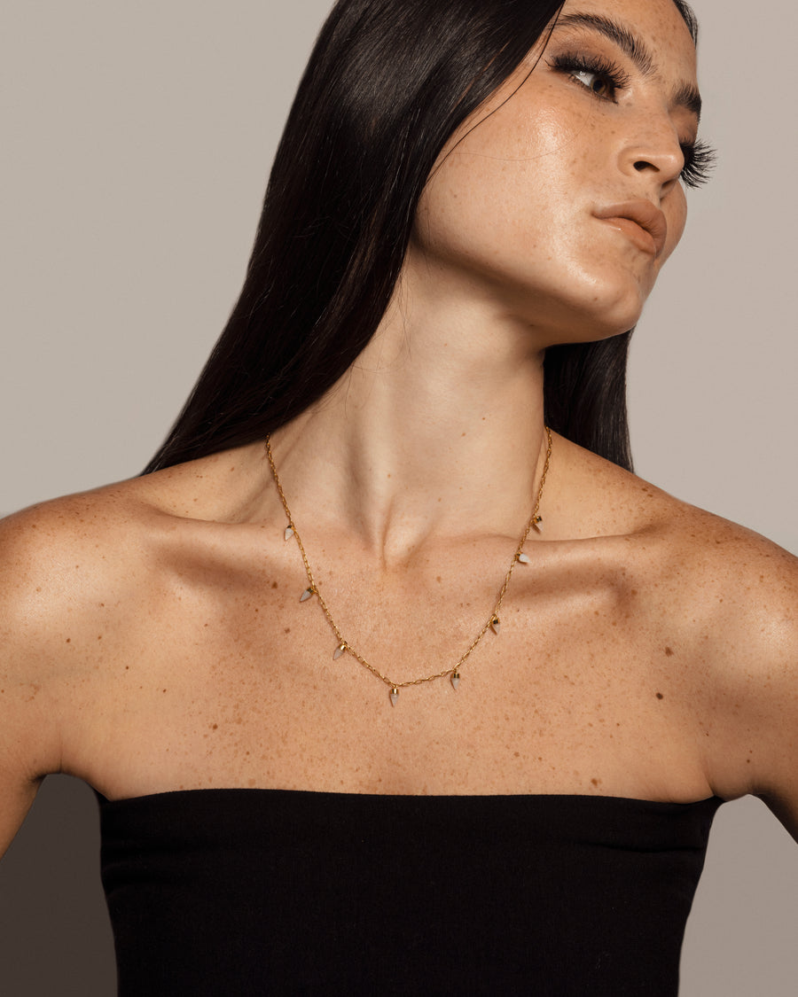 Woman with solid yellow gold necklace with multiple pendants